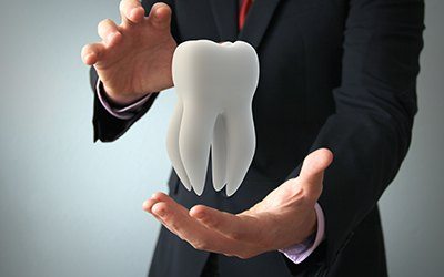 business man holding tooth
